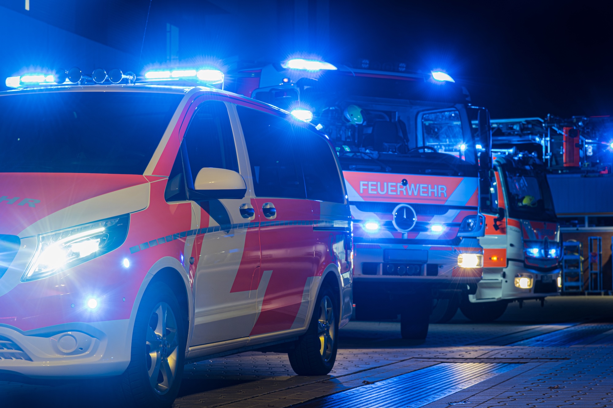 firefighters in action at a warehouse fire scene, emergency vehicles, professional photography, dramatic lighting